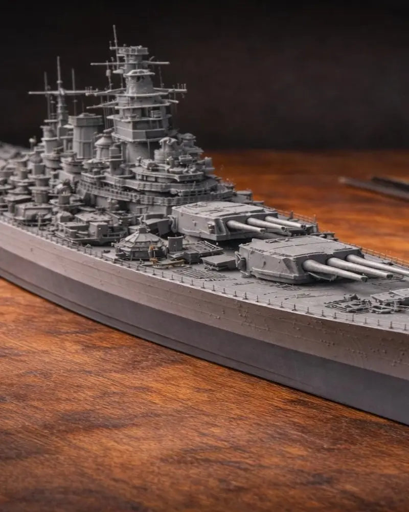 Detailed battleship scale model displayed on workshop table